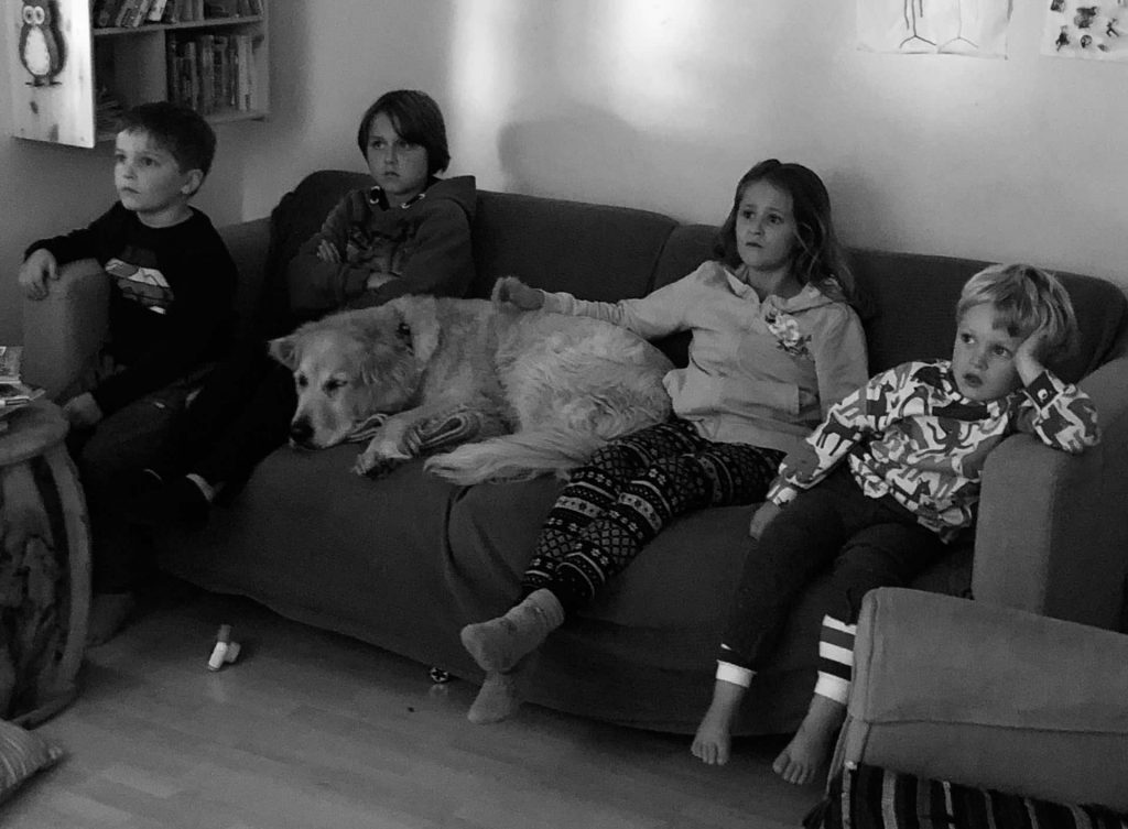 Timber liegt mit Kindern auf der Couch